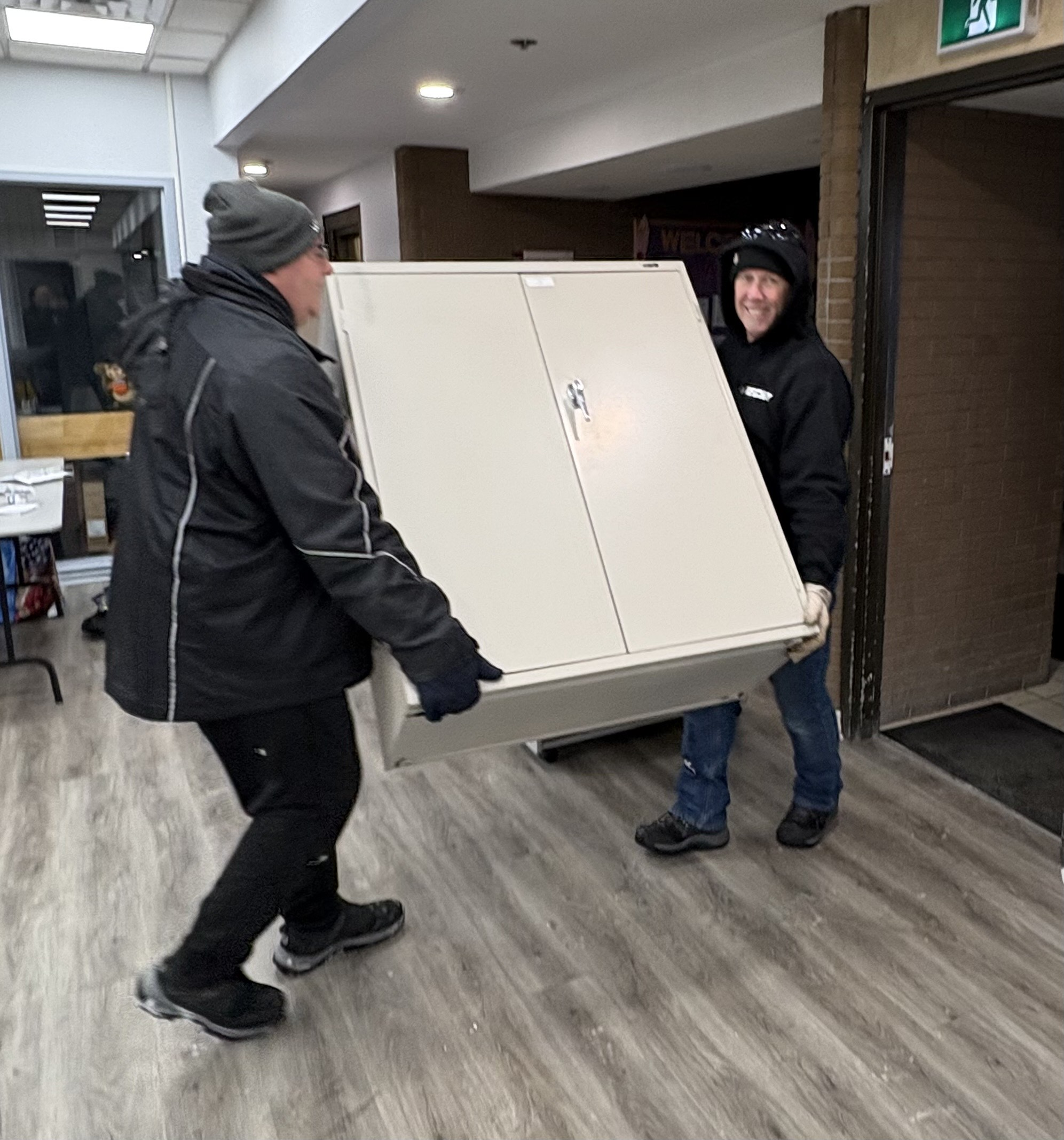 volunteers lifting cabinet